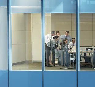 Vista desde una ventana a un equipo discutiendo en una oficina